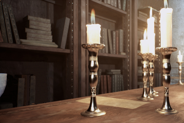 Candles on a long wooden table with papers and scrolls for research. Bookshelves line the walls and are filled with books of all shapes and sizes.