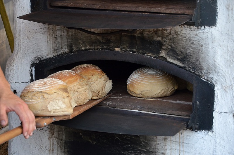 Freshly baked bread coming out of an old time wood fired oven